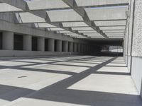 concrete and steel structure with low shadows, in an open parking lot, with empty spaces for cars and pedestrians