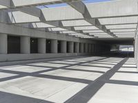 concrete and steel structure with low shadows, in an open parking lot, with empty spaces for cars and pedestrians