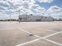 a parking lot with a building behind it and two empty areas in the middle of the picture