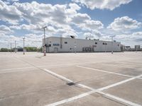 a parking lot with a building behind it and two empty areas in the middle of the picture