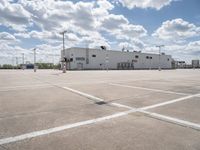 a parking lot with a building behind it and two empty areas in the middle of the picture