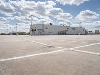 a parking lot with a building behind it and two empty areas in the middle of the picture