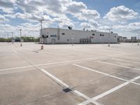 a parking lot with a building behind it and two empty areas in the middle of the picture