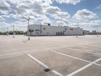 a parking lot with a building behind it and two empty areas in the middle of the picture