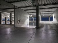 a dimly lit parking garage, showing the ground, ceiling and lights in it, all by itself