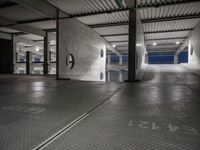 a dimly lit parking garage, showing the ground, ceiling and lights in it, all by itself