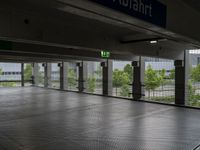 a parking garage with metal floors and walls, looking into some trees below the ceiling