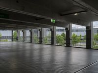 a parking garage with metal floors and walls, looking into some trees below the ceiling