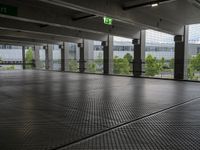 a parking garage with metal floors and walls, looking into some trees below the ceiling