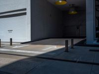 a gray walkway leading up to a building next to a yellow light lantern on top