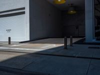 a gray walkway leading up to a building next to a yellow light lantern on top