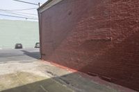 there is a man standing outside in front of the red brick wall of an old building