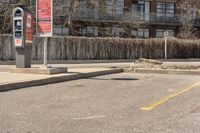 there are two parking meters with one parking sign on each corner and another sign that is sitting beside the street