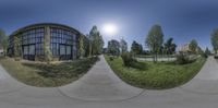 a panorama lens in the shape of a circle next to a park and building with grass