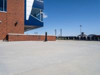 a parking lot that has concrete floor and blue sky in the background with buildings near by