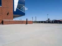 a parking lot that has concrete floor and blue sky in the background with buildings near by