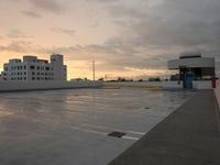 the roof has been damaged as sun sets over the parking lot in the foreground