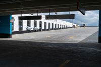 an empty building with some parking spaces in it's middleground, and cars parked nearby