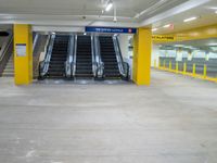 an empty parking garage with the escalators closed and several stairs inside it at a mall