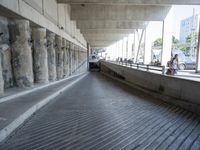 concrete walkway with cars and pedestrians on roadway area with bridge crossing overpass and elevated overpass