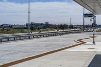 the walkway is concrete at the train station and beside the street is an empty parking space