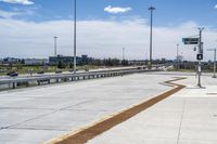 the walkway is concrete at the train station and beside the street is an empty parking space