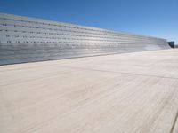 this is a concrete wall in a large building with many windows that are white and red