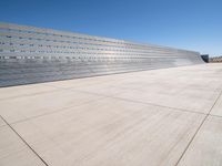 this is a concrete wall in a large building with many windows that are white and red