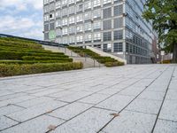 an outdoor park with steps leading to the office buildings and green plants in between them