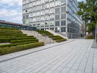 an outdoor park with steps leading to the office buildings and green plants in between them