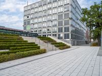 an outdoor park with steps leading to the office buildings and green plants in between them