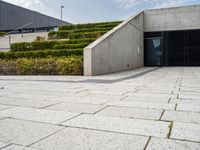 there is an open space with steps and plants on either side of the building as well