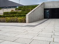 there is an open space with steps and plants on either side of the building as well