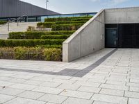 there is an open space with steps and plants on either side of the building as well