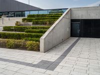 there is an open space with steps and plants on either side of the building as well