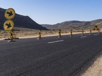 several traffic cones are lined up along the road and on the ground are yellow signs