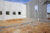 a building is being built with several different openings and windows, and cement walls and cement floors