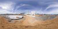 an outside building being built next to a beach on land and the sky is partly cloudy