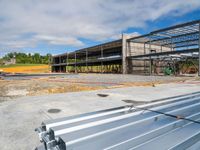 a building being constructed and covered with metal slats in front of a blue sky