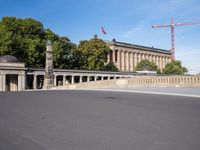 a large building under construction and a crane above it, above the road, on the city bridge