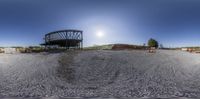 a fisheye photograph shows a construction site near a large building with a sky background