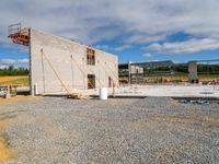 there is a building being constructed with concrete blocks and cement slabs in it and there are construction tools on the ground