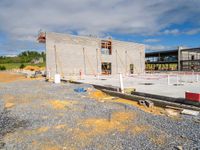 there is a building being constructed with concrete blocks and cement slabs in it and there are construction tools on the ground