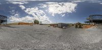 a panoramic view of a construction site with a building in the background, taken through a fish - eye lens