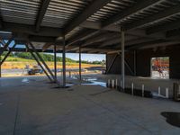 an indoor warehouse on the side of a large lot under construction for a new business