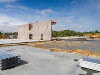 a concrete building that has some steel rods on it's side on a building site with a sky background