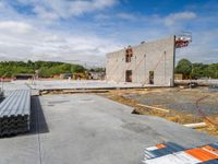 a concrete building that has some steel rods on it's side on a building site with a sky background