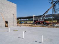 a construction site being worked on with a crane in the background holding up the floor for the roof