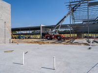 a construction site being worked on with a crane in the background holding up the floor for the roof