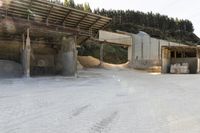 sand being turned to sand by the truck as it drives around a building structure with a covered roof